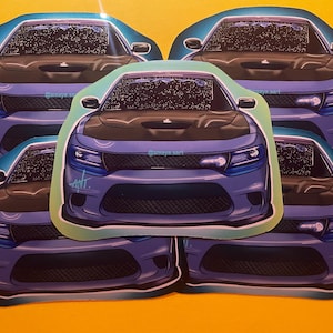 May include: Four blue Dodge Charger car stickers with a black hood and a white and blue design. The stickers are on a yellow surface.