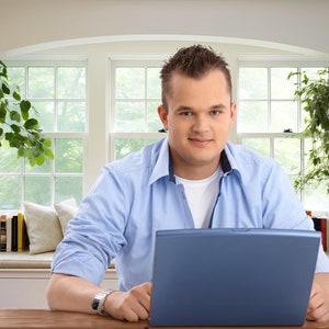 Virtual background of man sitting at desk containing laptop and in front of window seat with bookshelf for zoom and virtual meeting streaming backdrop.