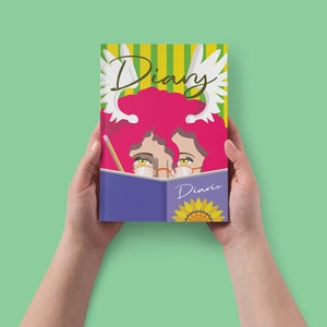 Puede incluir: Una agenda morada con la palabra "Diary" escrita en la portada en letra cursiva. La portada también presenta un girasol y una mujer con cabello rosado y alas de ángel asomándose por detrás del libro.