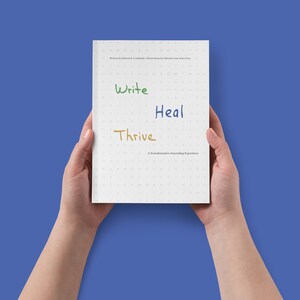Puede incluir: Un diario blanco con las palabras "Write", "Heal" y "Thrive" escritas en diferentes colores en la portada. El diario es una experiencia de diario transformadora.