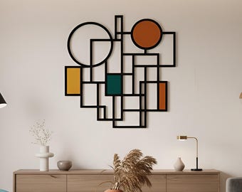 May include: A modern living room featuring a geometric wall art piece with black outlines and colorful orange, green, and yellow shapes. The room includes a gray sofa, a teal armchair, and a wooden cabinet.
