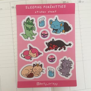 Könnte beinhalten: Eine Sticker-Tafel mit rosa Hintergrund, auf der verschiedene schlafende Pokémon-Charaktere abgebildet sind. Zu den Charakteren gehören eine grüne Katze, eine blaue Katze, eine rote Katze, eine lila Katze, eine braune Katze und eine graue Katze. Die Tafel enthält außerdem zwei blaue Sprühflaschen und drei Pokébälle. Der Text "SLEEPING POKÉKITTIES sticker sheet" befindet sich oben auf der Tafel. Der Text "@daily_crispy" befindet sich unten auf der Tafel.