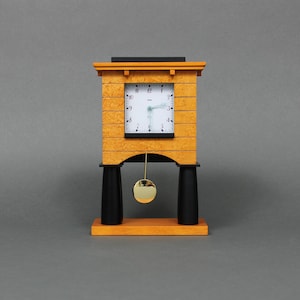 May include: A yellow and black wooden clock with a pendulum. The clock face has black Roman numerals and a white background.