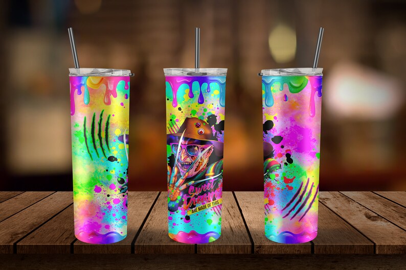 May include: Three stainless steel tumblers with colorful paint splatter designs. The center tumbler features a graphic of Freddy Krueger from the movie "A Nightmare on Elm Street" with the text "Sweet Dreams Are Made of This".