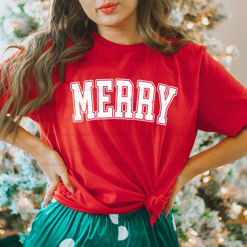 May include: Red t-shirt with white text that says "MERRY" in a varsity style font. The shirt is tied at the waist and worn with green and white polka dot pants.