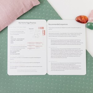 A close-up of a white and green yoga mat with a pink pillow and three crystals. The mat has a text overlay that reads "My Home Yoga Practice" and "Recommended Sequences".