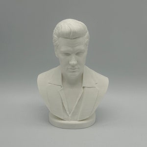 May include: White bust sculpture of a man with slicked back hair. The sculpture is on a white base.