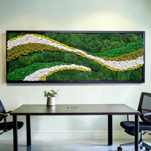 Puede incluir: Una pieza de arte mural rectangular que presenta musgo preservado en varios tonos de verde, amarillo y blanco, dispuestos en ondas horizontales fluidas y superpuestas. La composición de musgo texturizado está enmarcada en madera negra.