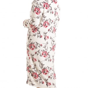 Puede incluir: Una bata blanca de manga larga con estampado floral en tonos rosa y gris. La bata tiene un cuello chal y un cintur&oacute;n de atar.