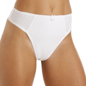 Pode incluir: Uma caneca de cerâmica branca com uma alça preta e o texto "But First, Coffee" em preto, com uma fonte manuscrita. A caneca está sobre uma superfície branca.