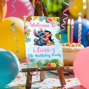 May include: A blue and pink welcome sign with a cartoon image of Stitch and Lilo. The sign says "Welcome to Olivia's 5th Birthday Party".