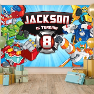 Pode incluir: Um pano de fundo azul e branco com uma imagem de desenho animado de um grupo de robôs. O texto "JACKSON IS TURNING 8" está no centro do pano de fundo. O pano de fundo é decorado com balões coloridos.