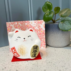Maneki Neko japonais chat porte-bonheur blanc pour une bonne santé avec tapis et présentoir. Feng Shui.