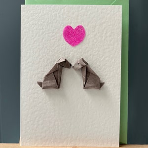 Carte de voeux en origami représentant une paire de chiens assis et un coeur