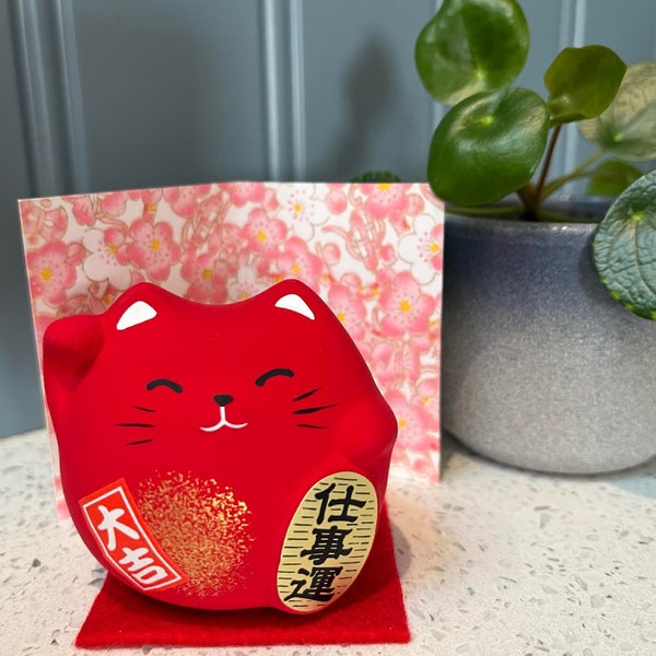 Gatto fortunato rosso giapponese Maneki Neko per la prosperità negli affari con tappetino e cartoncino. Feng Shui.