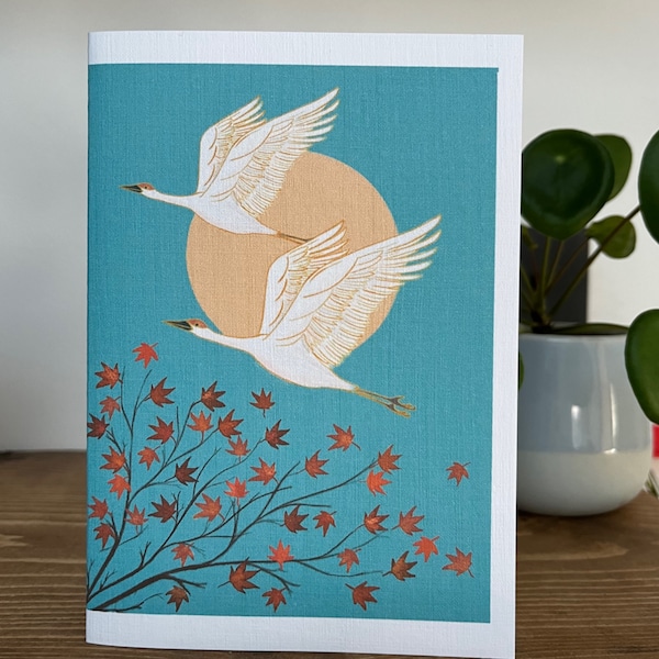 Greetings card 2 cranes flying over a Japanese acer tree