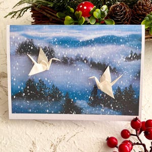Carte de Noël faite main, deux grues en origami au-dessus d'une forêt enneigée brumeuse et enneigée, papier Yuzen japonais pour quelqu'un de spécial