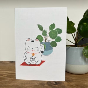 Japanische Grußkarte Weiße Glückskatze und Geldpflanze Pilea peperomioides
