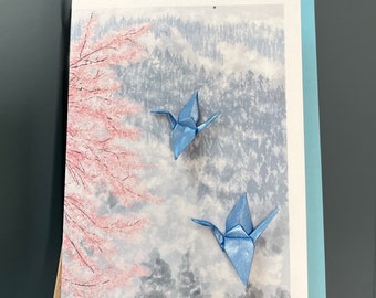 Carte de voeux Grues en origami faites main, volant au-dessus de la brume matinale et des fleurs de printemps