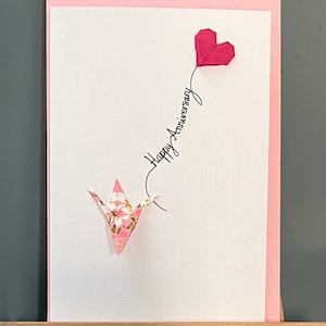 Handgemachte Jubiläumskarte - Origami-Kranich, rosa Blüte und Fuchsia-Herzballon - 'Happy Birthday'