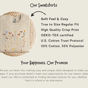 May include: A beige sweatshirt with a floral and butterfly print. The text "Our Sweatshirts" is at the top of the image. The text "Soft Feel & Cozy" is below the image of the sweatshirt. The text "True to Size Regular Fit" is below "Soft Feel & Cozy". The text "High Quality Crisp Print" is below "True to Size Regular Fit". The text "OEKO-TEX certified" is below "High Quality Crisp Print". The text "U.S. Cotton Trust Protocol" is below "OEKO-TEX certified". The text "50% Cotton, 50% Polyester" is below "U.S. Cotton Trust Protocol". The text "Your Happiness. Our Promise" is below the sweatshirt image. The text "We put our heart into crafting cozy and unique items designed to make you happy. If your purchase doesn't meet your expectations for any reason, please reach out. We're committed to finding the best solution for you, whether that's a refund or an alternative." is below "Your Happiness. Our Promise".