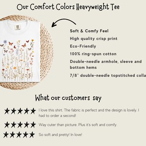 May include: White heavyweight tee shirt with a floral and butterfly design. The text "Our Comfort Colors Heavyweight Tee" is at the top of the image. The text "Soft & Comfy Feel", "High quality crisp print", "Eco-Friendly", "100% ring-spun cotton", "Double-needle armhole, sleeve and bottom hems", "7/8" double-needle topstitched collar" is listed below the image of the shirt. The text "What our customers say" is at the bottom of the image. Three five-star ratings are shown below the text.