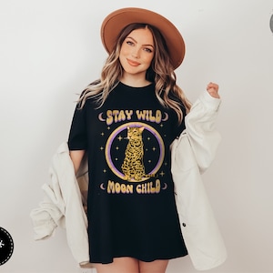 May include: Black t-shirt with a graphic of a leopard sitting in a circle with the text "Stay Wild Moon Child" in a retro font.