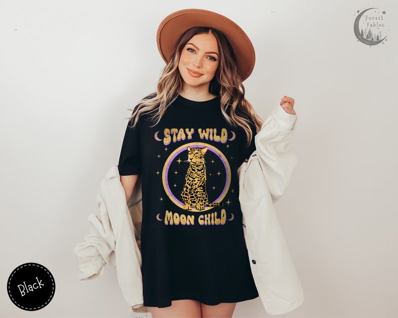May include: Black t-shirt with a graphic of a leopard sitting in a circle with the text "Stay Wild Moon Child" in a retro font.