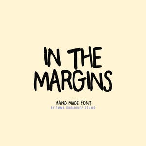 May include: A digital graphic featuring the black text IN THE MARGINS in a hand-drawn style font against a pale yellow background. Below the main text, smaller black text reads HAND MADE FONT, followed by BY EMMA RODRIGUEZ STUDIO in purple.