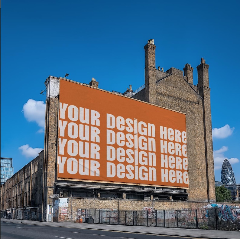 May include: A large orange billboard with the text "Your Design Here" repeated four times. The billboard is mounted on the side of a brick building.