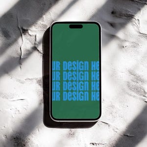 May include: A smartphone with a green screen displaying the text "UR DESIGN HERE" repeated four times in blue.