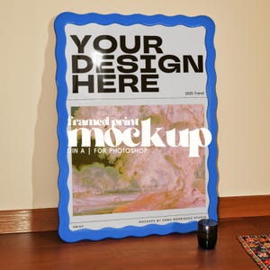 Peut inclure: Maquette d'impression encadrée avec un cadre bleu ondulé. L'impression affiche le texte "YOUR DESIGN HERE" en gras noir, avec "2025 Trend" en dessous. La section inférieure affiche "framed print mockup DIN A | FOR PHOTOSHOP".