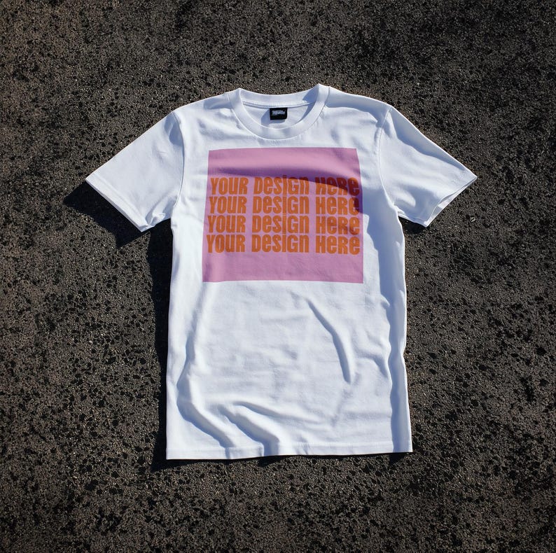 May include: White t-shirt with a pink square print that says "Your design here" four times.