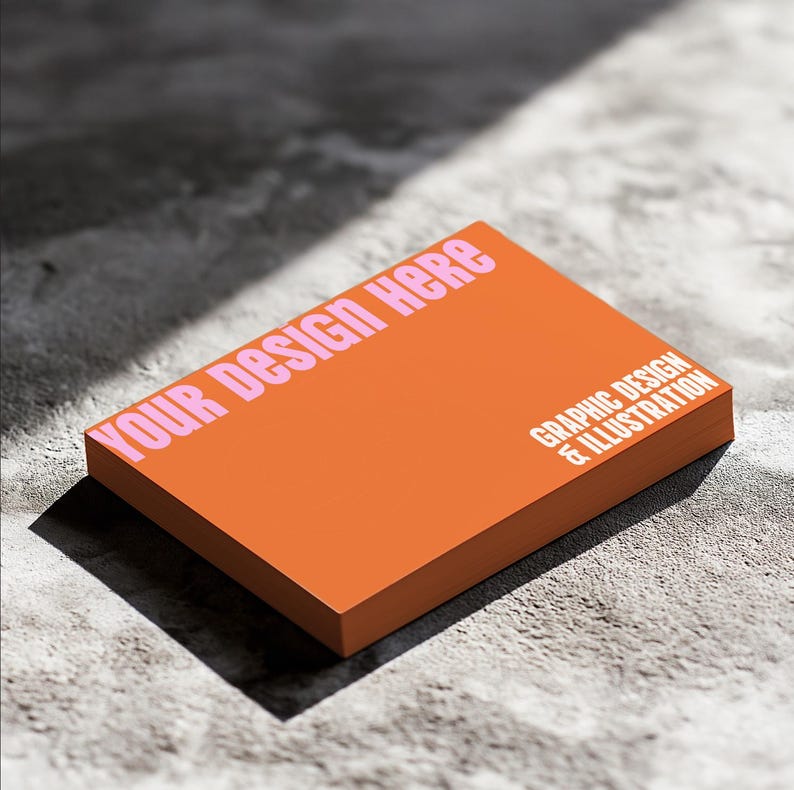 May include: Orange business card mockup with the text "YOUR DESIGN HERE" in pink letters and the text "GRAPHIC DESIGN & ILLUSTRATION" in white letters.