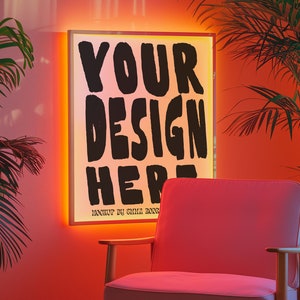 May include: A pink armchair with wooden legs sits in front of a white framed light box with the text "YOUR DESIGN HERE" in black. The light box is illuminated with a warm orange glow. The wall behind the chair is a light pink color.
