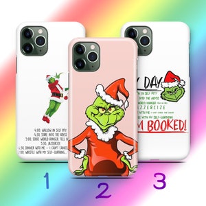 May include: Three phone cases featuring the Grinch. One case is white with the Grinch in a Santa suit and text. Another is pink with the Grinch in a Santa suit. The third case is white with the Grinch and text.