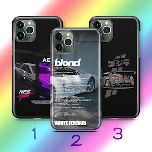 Puede incluir: Tres fundas de smartphone negras con diseños automotrices. La funda izquierda muestra un coche blanco con el texto 'NFS Heat'. La central muestra un coche deportivo blanco con 'blond' y 'WHITE FERRARI'. La derecha muestra un gráfico de un coche gris.