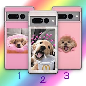 Op de afbeelding: Drie roze telefoonhoesjes met verschillende afbeeldingen van honden. De eerste hoes heeft een golden retriever die op een roze donut ligt. De tweede hoes heeft een golden retriever puppy die drinkt uit een McDonald's-beker. De derde hoes heeft een bruin-witte poedel die zijn kop door een gat in de hoes steekt.