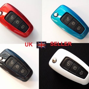 May include: Four key fobs in different colours: red, blue, black, and white. Each fob has three buttons with symbols for lock, unlock, and boot release.