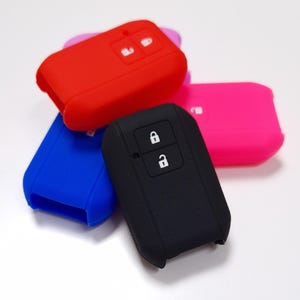 May include: Assortment of silicone key covers in red, blue, pink, and black. Each cover has two buttons with lock icons.