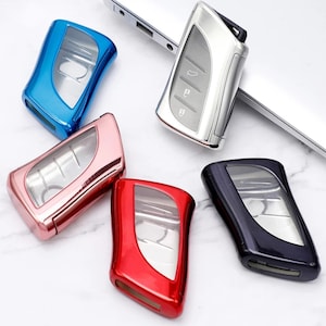 以下が含まれることがあります： 5種類のキーフォブカバー。カバーはプラスチック製で、キーフォブが見えるクリアウィンドウが付いています。カバーの色は、青、ピンク、赤、黒、銀です。