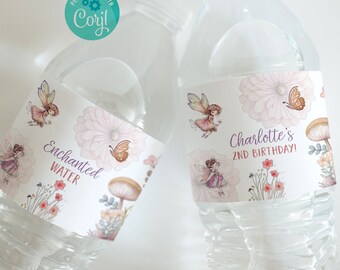 Puede incluir: Dos botellas de agua de plástico transparente con etiquetas personalizadas. Las etiquetas presentan un tema de hadas caprichoso con mariposas, flores y hongos. Una etiqueta dice "Agua encantada" y la otra dice "Charlotte's 2nd Birthday!"