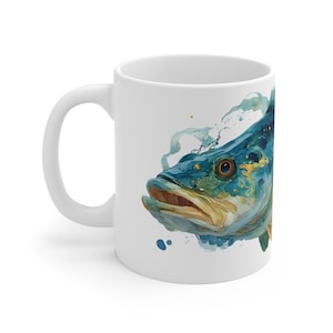May include: White ceramic mug featuring a watercolor illustration of a blue and gold fish. The fish has detailed scales and an open mouth. The mug has a curved handle and is suitable for hot or cold beverages.
