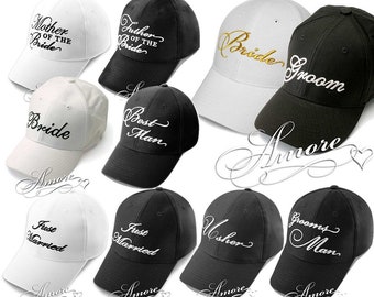 May include: Assorted baseball caps in white and black, embroidered with wedding-related text. The caps include phrases like "Mother of the Bride," "Father of the Bride," "Bride," "Groom," "Best Man," "Just Married," "Usher," and "Grooms Man."