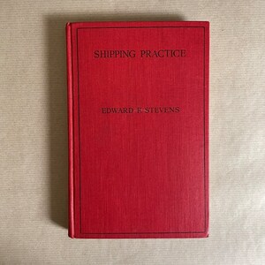 May include: A red hardback book with the title "SHIPPING PRACTICE" and the author "EDWARD F. STEVENS" printed on the front cover.