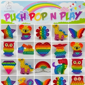 May include: A collection of 20 colorful rainbow push pop fidget toys in various shapes and designs, including a star, owl, dinosaur, heart, rainbow, butterfly, and more. The toys are made of silicone and have a satisfying popping sound when pressed.