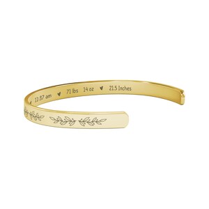 May include: Gold bangle bracelet with an engraved floral design and the text "11:37 am &hearts; 7.1 lbs 14 oz &hearts; 21.5 Inches".