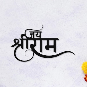 Op de afbeelding: Zwarte gestileerde tekst op een witte achtergrond. De tekst luidt "जय श्रीराम" in een decoratief lettertype. Het ontwerp bevat wervelingen en curven, met een kleine gele bloem in de rechterbenedenhoek.
