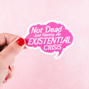 May include: Pink speech bubble sticker with the text "Not Dead Just Having An Existential Crisis".