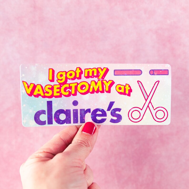 May include: A white sticker with a pink, yellow, and purple design. The sticker says "I got my VASECTOMY at claire's" with a pair of scissors in the corner.